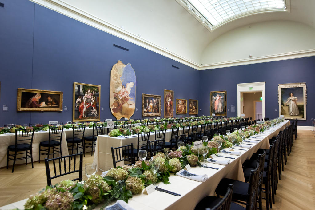 large art gallery with long event tables set for a meal
